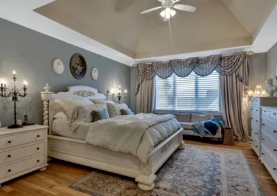 Luxurious master bedroom with elegant decor, ornate bed, large window, and decorative wall sconces.